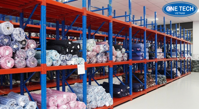 Kệ trưng bày vải đặt trong kho xưởng may giúp phân loại theo mã và màu